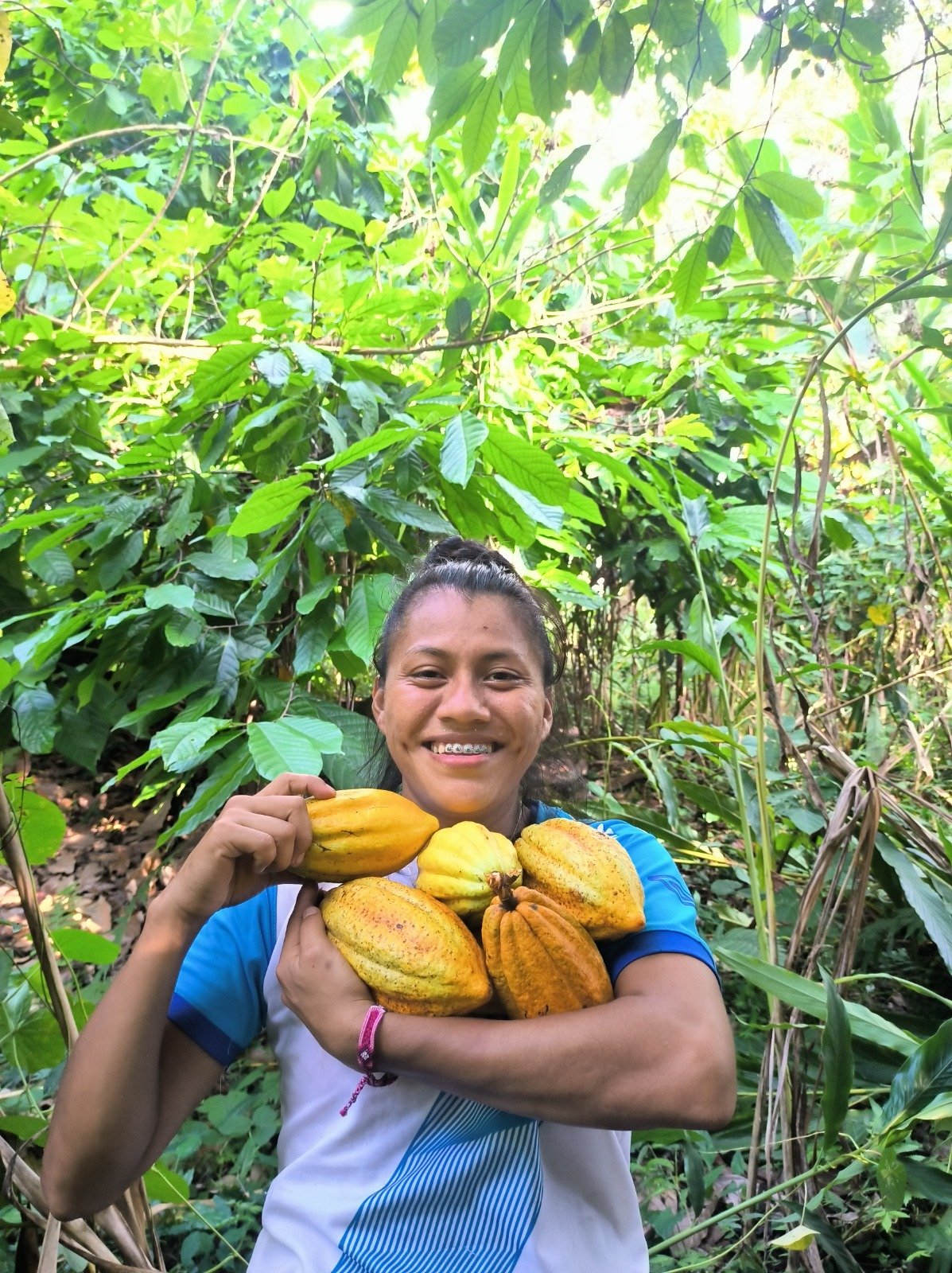  Beatriz Caal, sonríe mientras muestra las semillas de cacao que produjo en su huerto en Cobán Alta Verapaz. Crédito: Elías Oxom. 